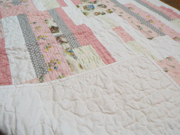 Corner flipped showing backing on Daisy Dreams pink baby quilt