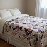 Handmade king quilt in lavender, rose, and sage tones styled in a cozy cottage bedroom with natural light and soft linen bedding.