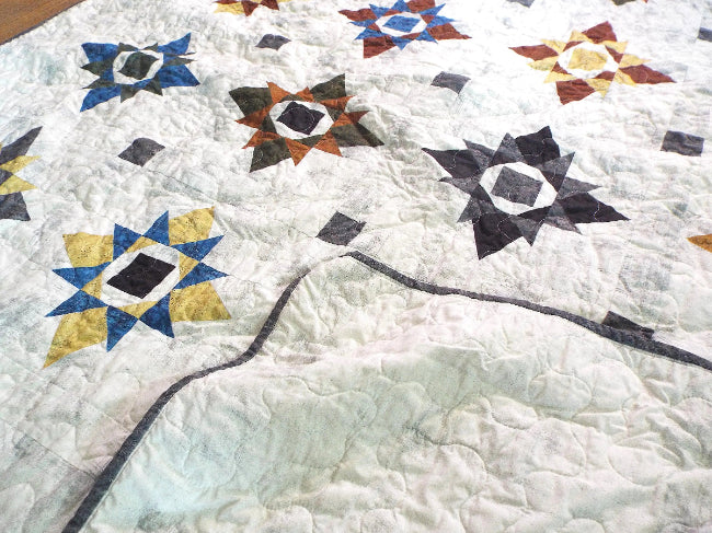 Starry Comfort handmade quilt with the backing flipped to show reverse