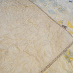 Folded corner showing fabric patterns and cotton backing of the Honeybloom queen quilt