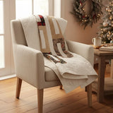 Elegant minimal holiday throw draped over the back of an armchair in the corner of a room