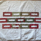 Flat lay of minimal holiday quilt in traditional colors