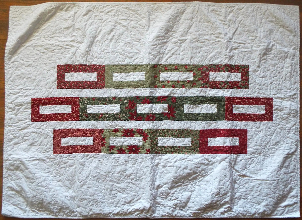 Flat lay of minimal holiday quilt in traditional colors