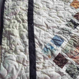 Edge view of the Of Ink and Thread King Quilt showing the contrasting charcoal border and fine quilting work.