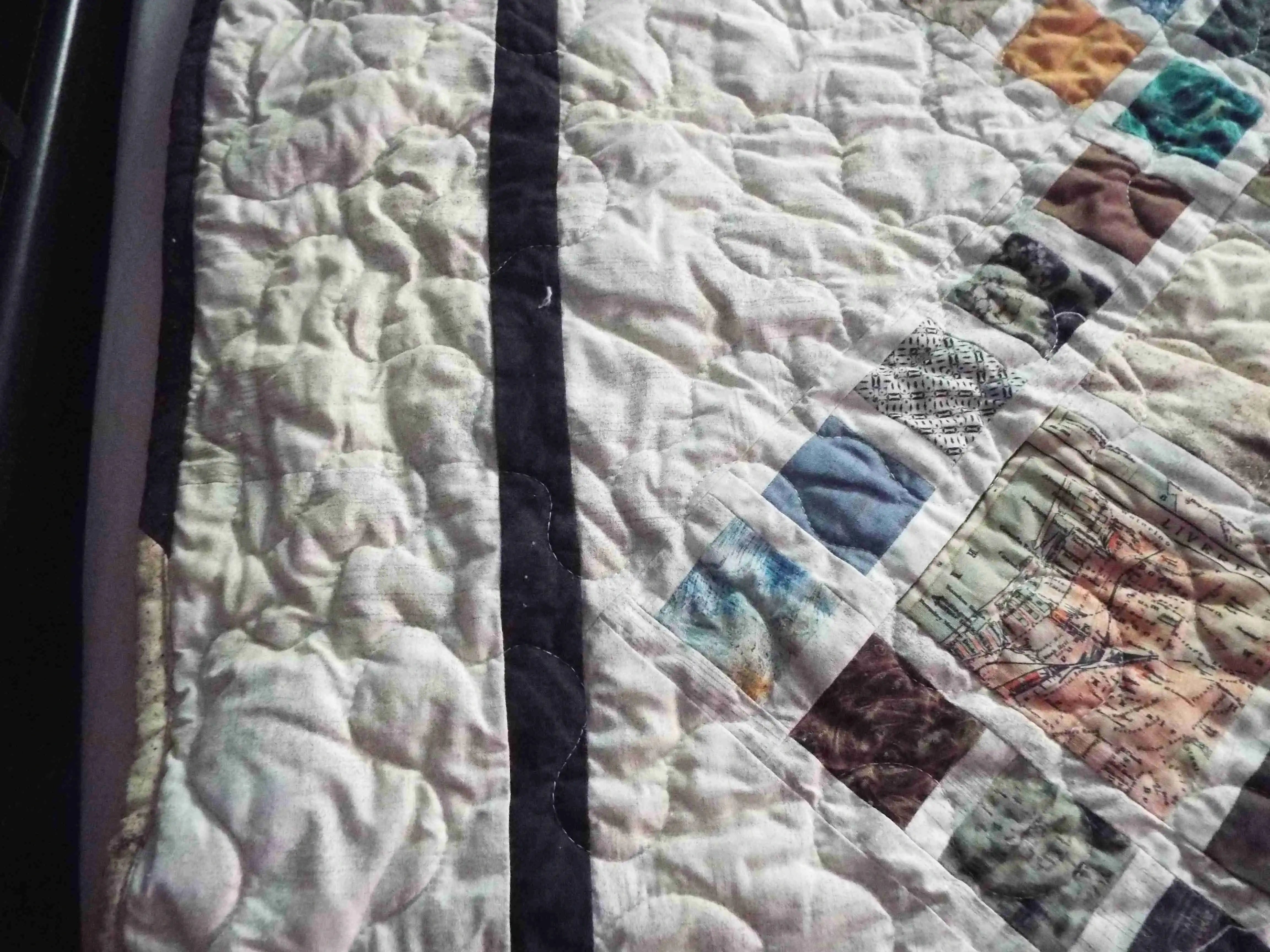 Edge view of the Of Ink and Thread King Quilt showing the contrasting charcoal border and fine quilting work.