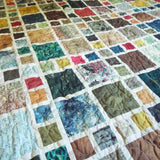 Detailed angle of the Of Ink and Thread King Quilt displaying layered textures, mixed patterns, and subtle stitching across cotton fabrics.