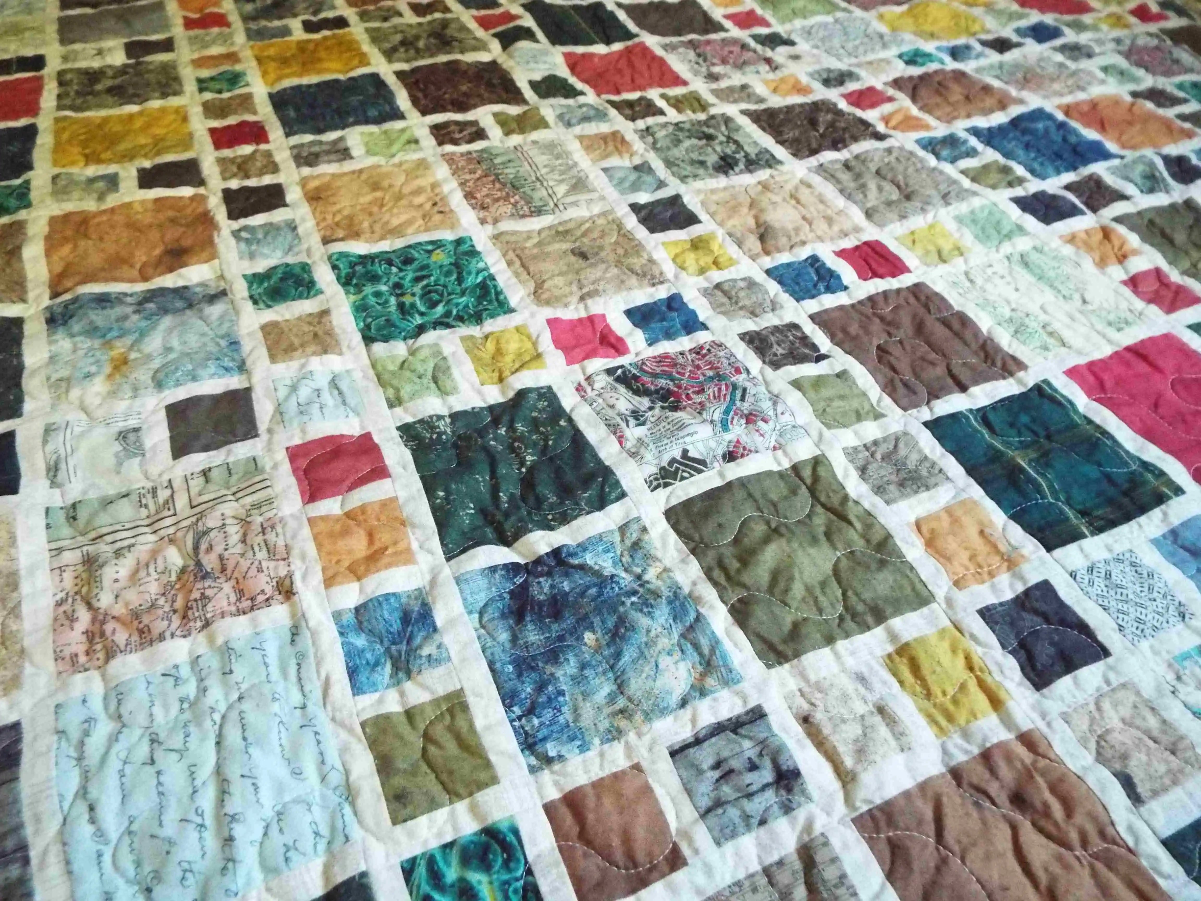 Detailed angle of the Of Ink and Thread King Quilt displaying layered textures, mixed patterns, and subtle stitching across cotton fabrics.