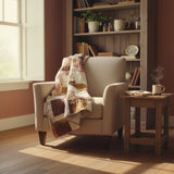 Rose gold handmade quilt draped over the side of a chair in a reading nook