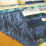 Angled shot of quilt with corner flipped up so show backing