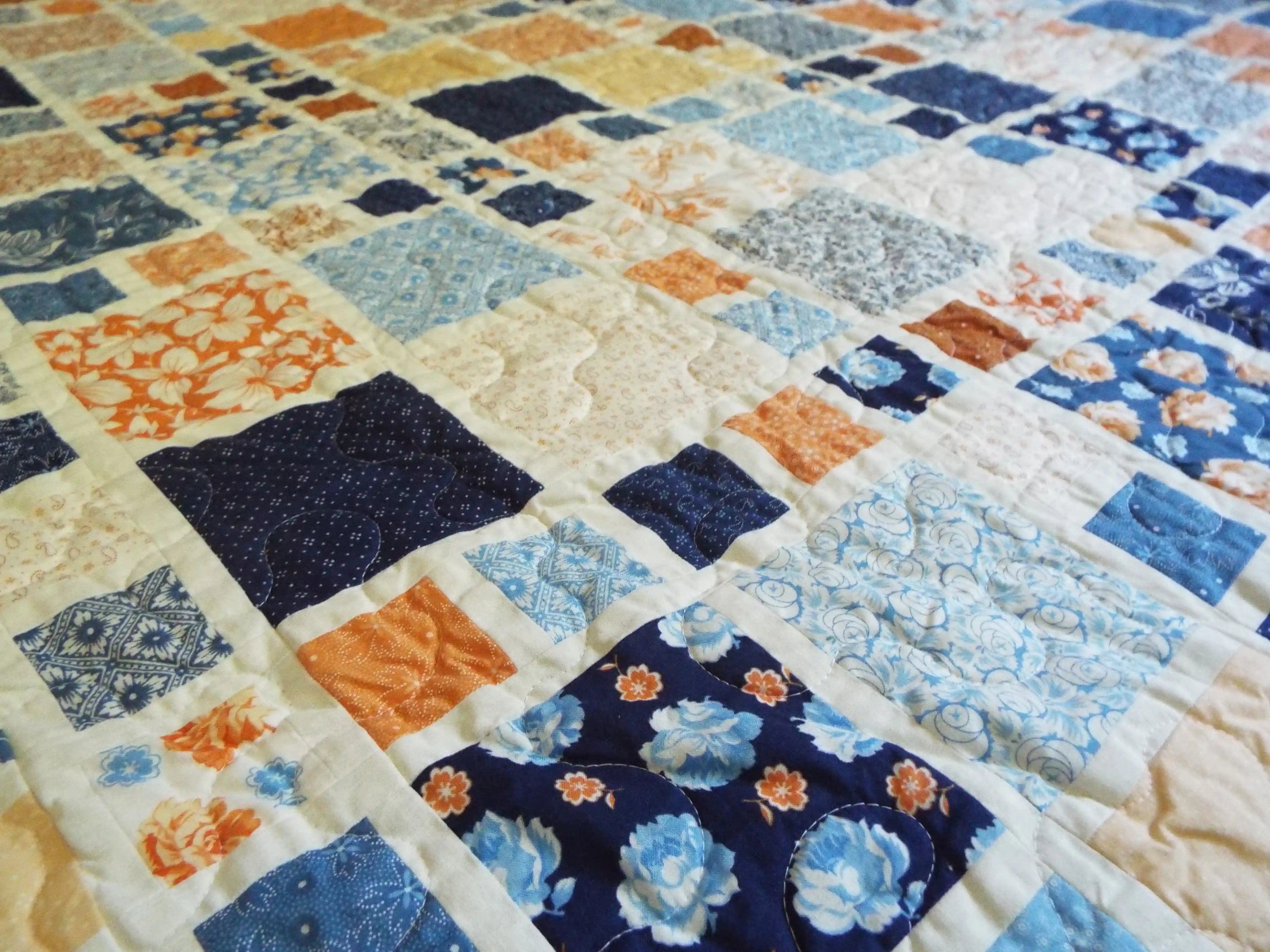 Close mid-range view showing intricate patchwork blocks and gentle quilting texture across the fabric.