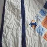 Quilted border detail showing the precise stitching and navy framing edge around the pattern.