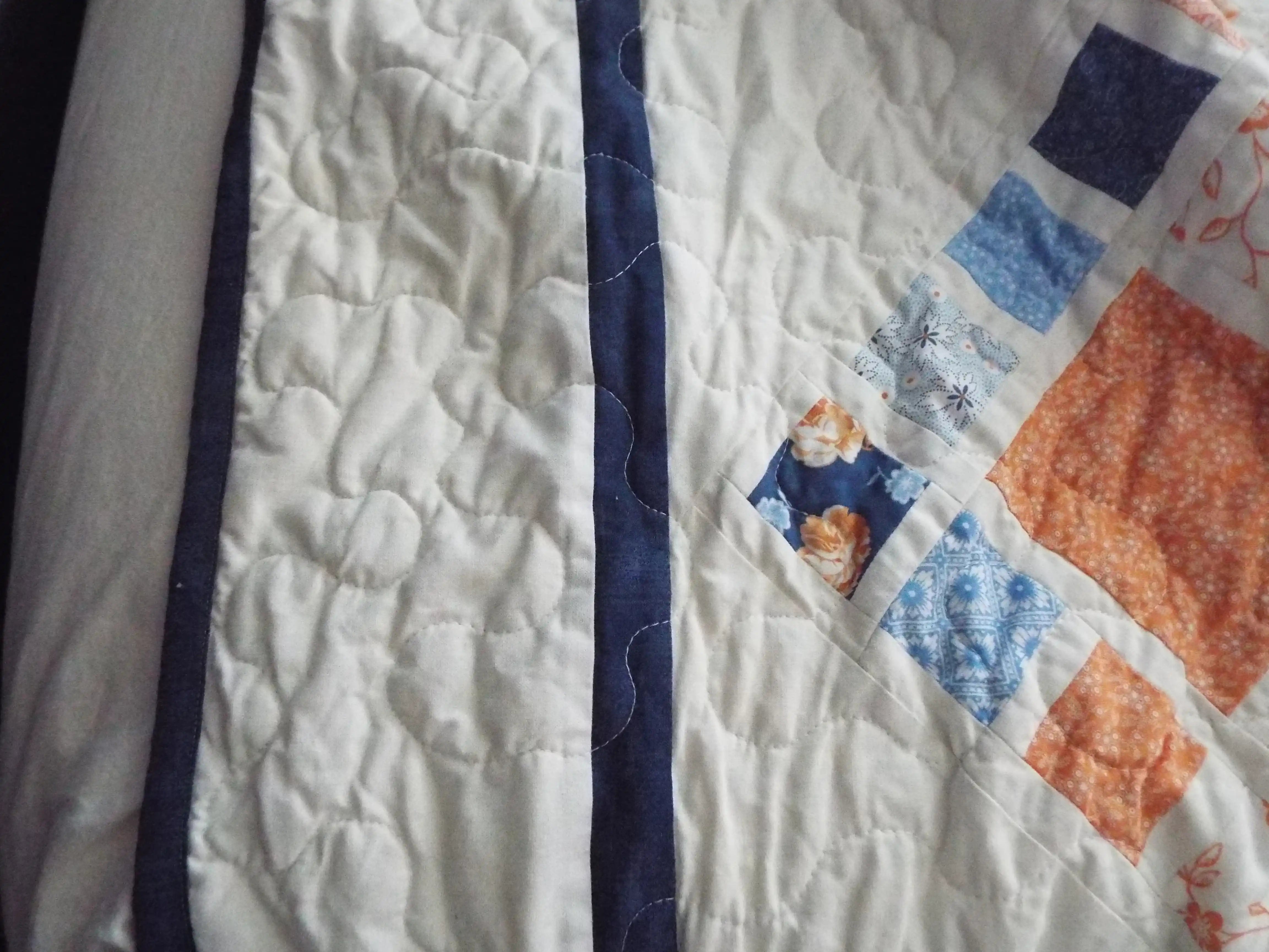 Quilted border detail showing the precise stitching and navy framing edge around the pattern.