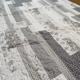 Angled flat lay of Starlit Trails gray baby quilt
