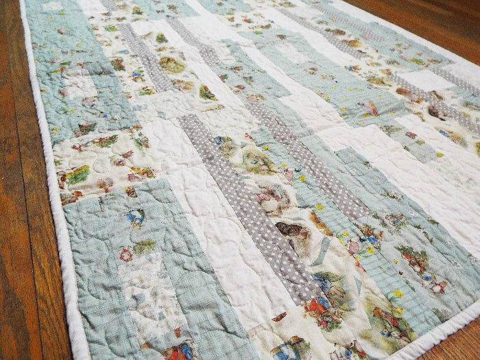 Twilight Tails blue baby quilt angled flat lay