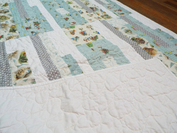 Twilight Tails blue baby quilt with corner flipped over to show backing