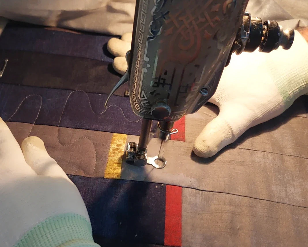 Hands guiding stitching on a lap quilt