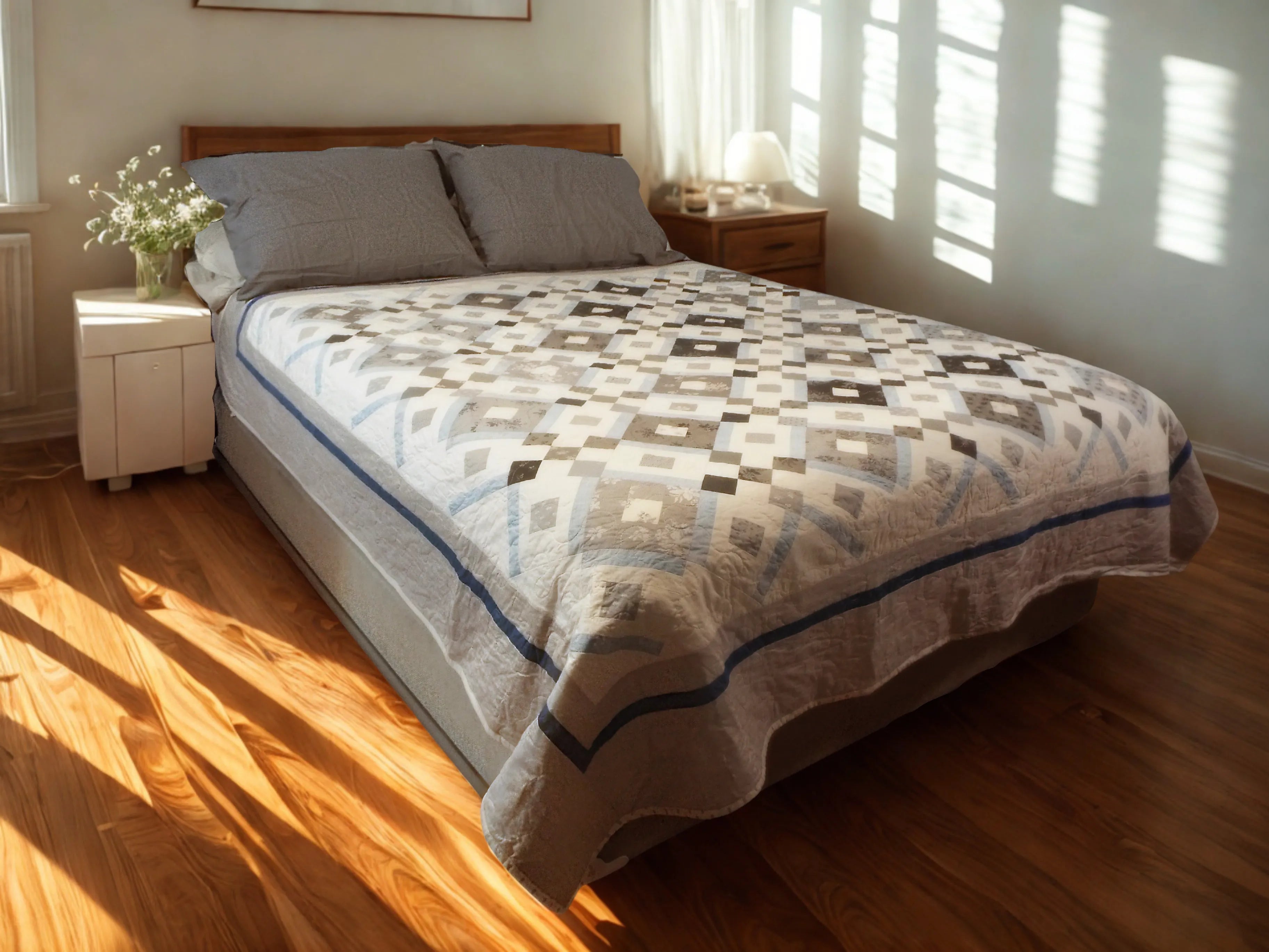 Black and white quilt on queen bed in a minimally decorated bedroom