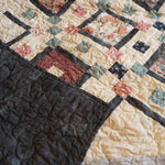Handmade twin floral quilt with corner flipped up to show backing and quilt top together