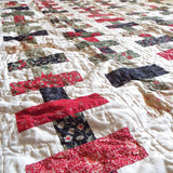 Angled shot of holiday throw in traditional colors in a brick piecing pattern