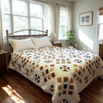 Adamstown quilt displayed on a bed in an airy bedroom with wooden floors and dressers