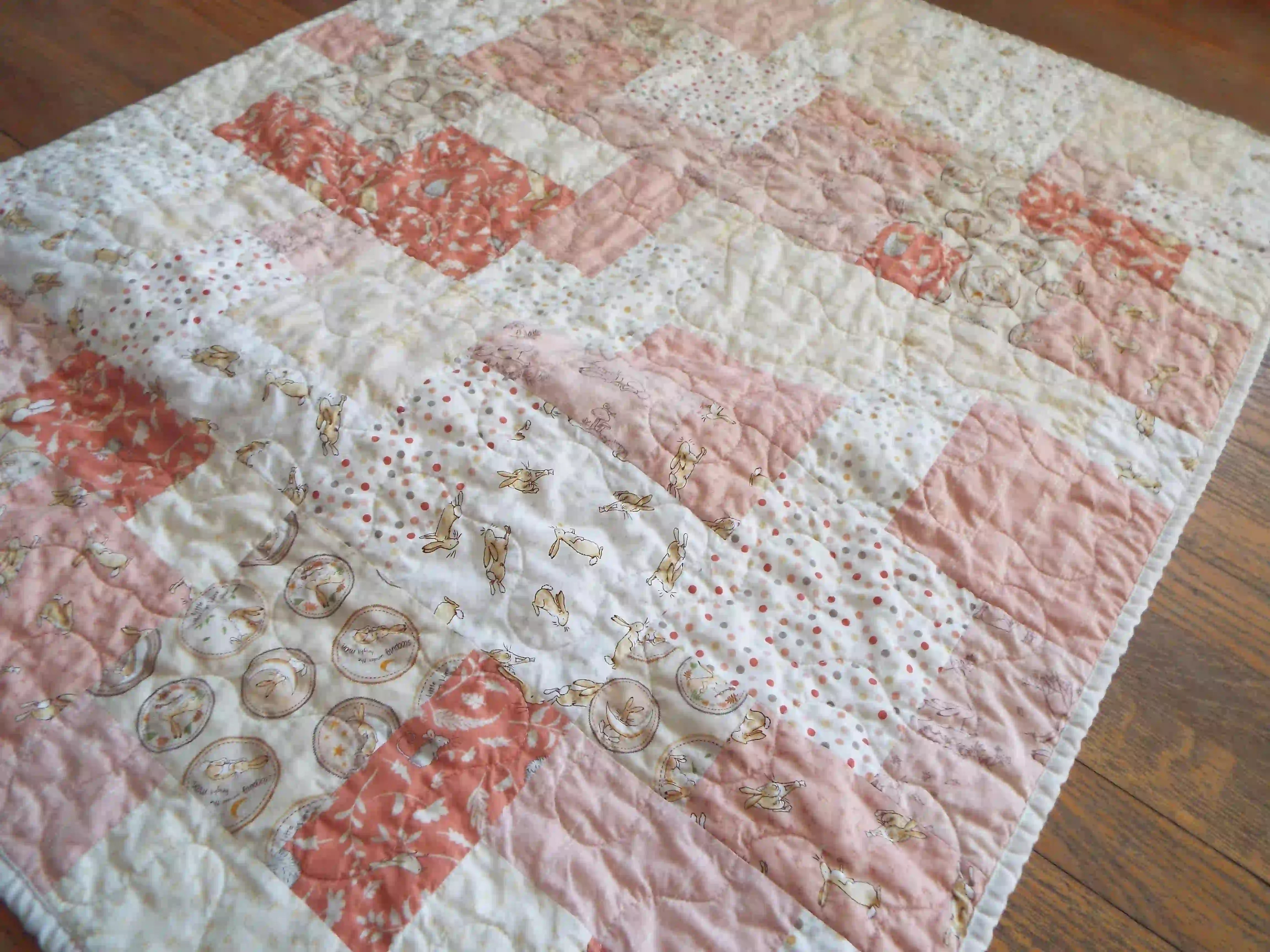 Angled lay of quilt showing detail in fabrics and stitching