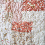 Detail shot of quilt showing close up of fabrics and stitching