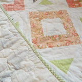 Close up of handmade quilt showing stitching on both backing and quilt top.