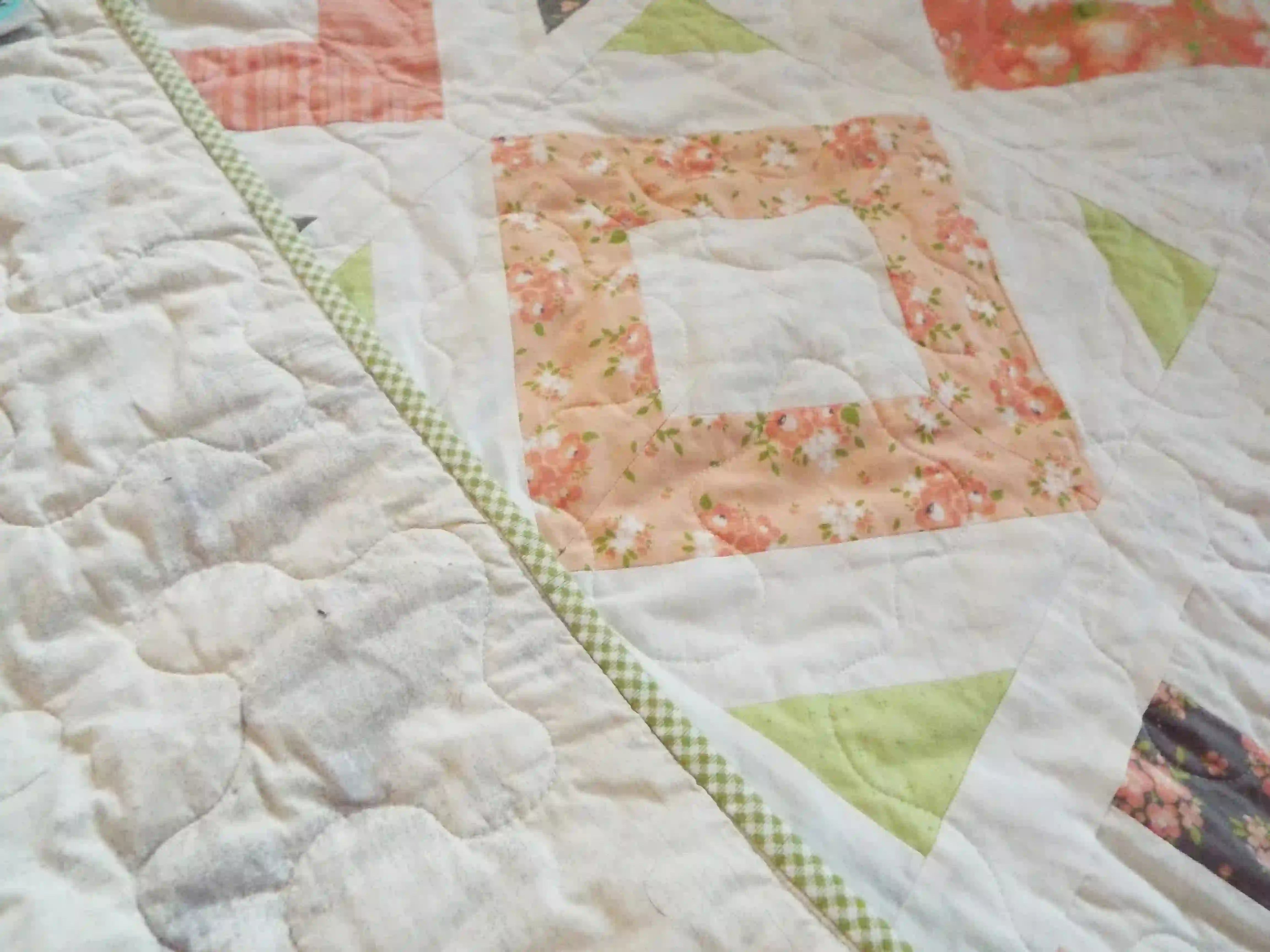 Close up of handmade quilt showing stitching on both backing and quilt top.