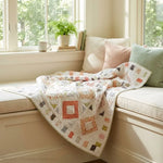 Handmade lap quilt shown in a corner window seat.