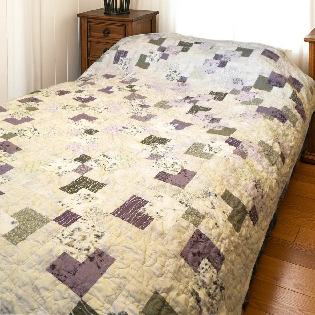 Purple and green twin quilt shown in a bright room