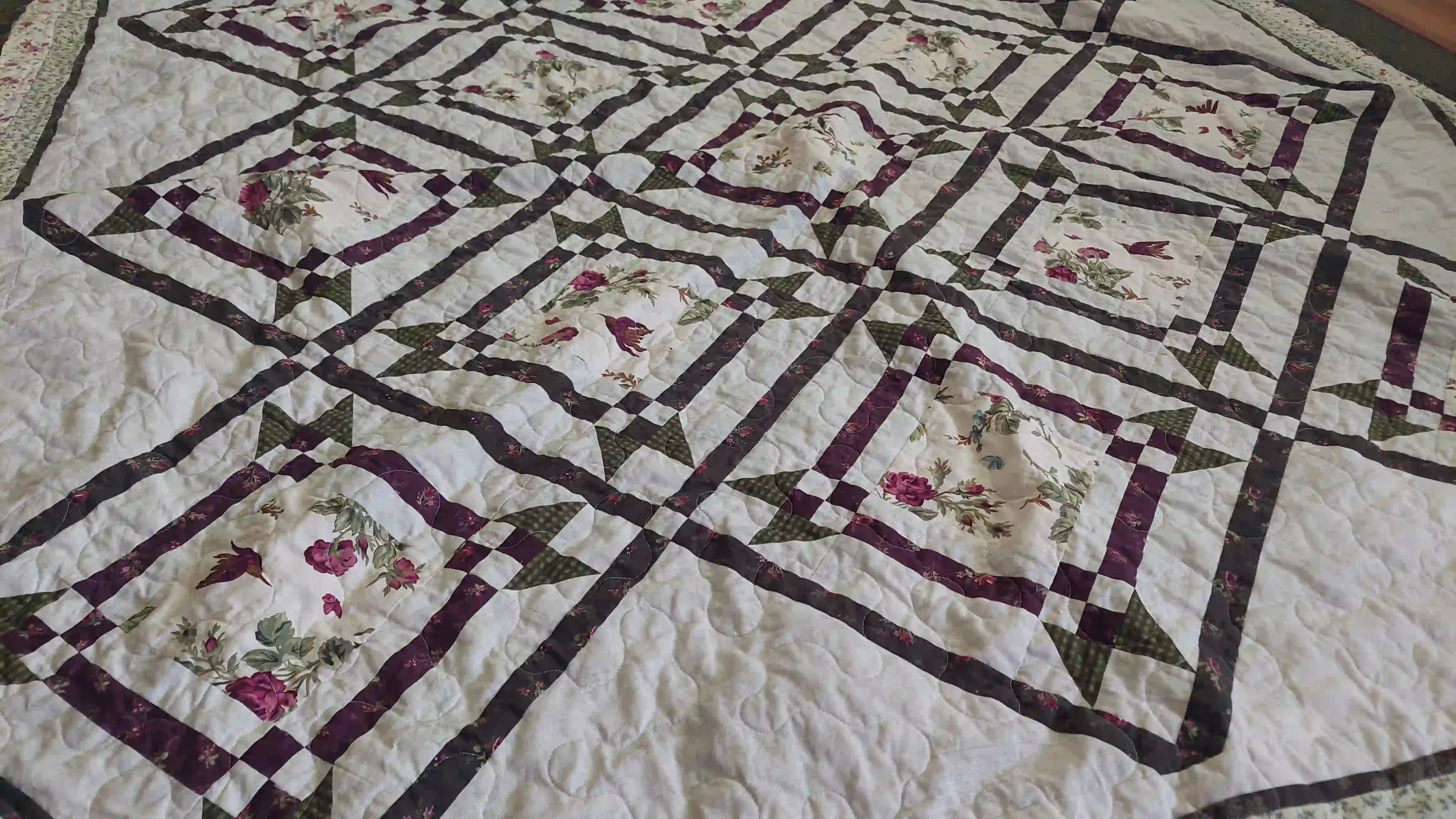 Angled lay of Avonlea Garden Twin Quilt showing fabric and design detail.