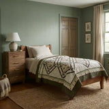Avonlea Garden Twin Quilt shown in simple sage room with wooden furniture.