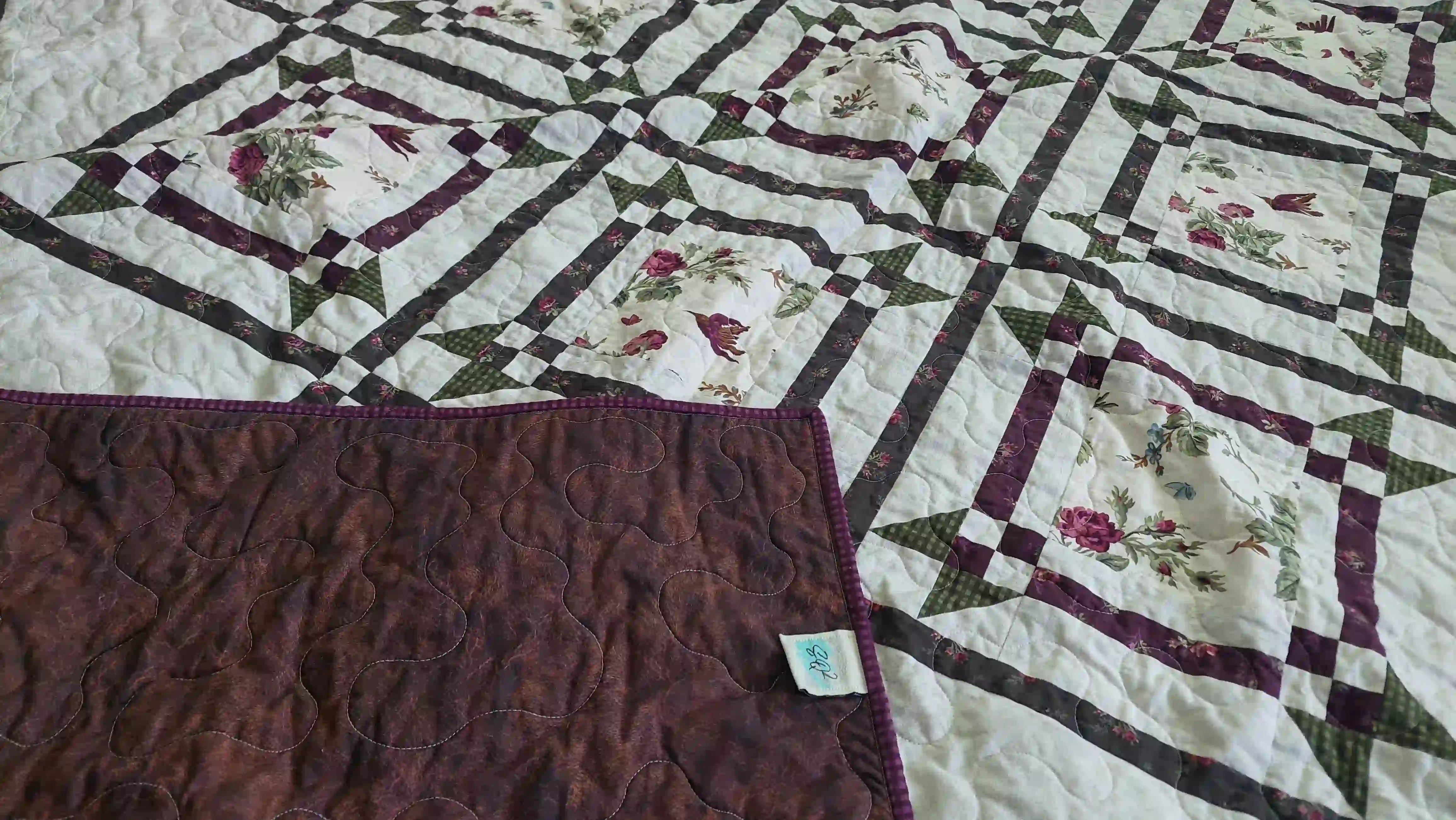 Corner flipped over on Avonlea Garden Twin Quilt showing backing against quilt top.