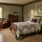 Avonlea Garden Twin Quilt shown in a traditional farmhouse inspired room with leather chair and wooden furniture.