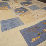 Overhead view of a blue bunny baby quilt with airy piecing and calming neutral tones, styled flat for a full view of the pattern and fabric details
