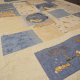 Overhead view of a blue bunny baby quilt with airy piecing and calming neutral tones, styled flat for a full view of the pattern and fabric details
