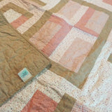 Blushing Pathways Baby Quilt shown with corner flipped over to see backing detail.