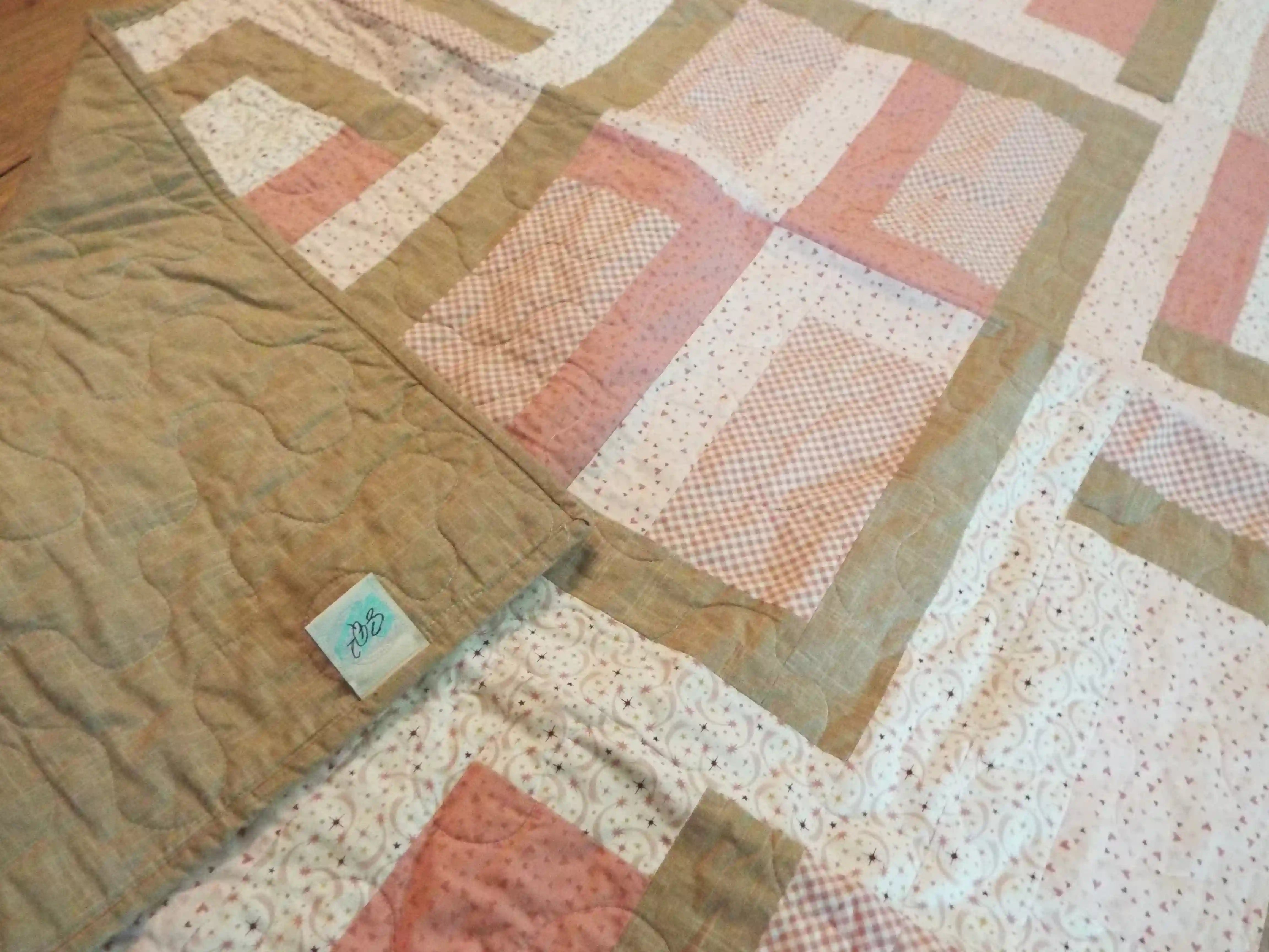 Blushing Pathways Baby Quilt shown with corner flipped over to see backing detail.