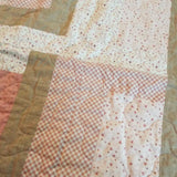 Detail of Blushing Pathways Baby Quilt showing quilt stitching.