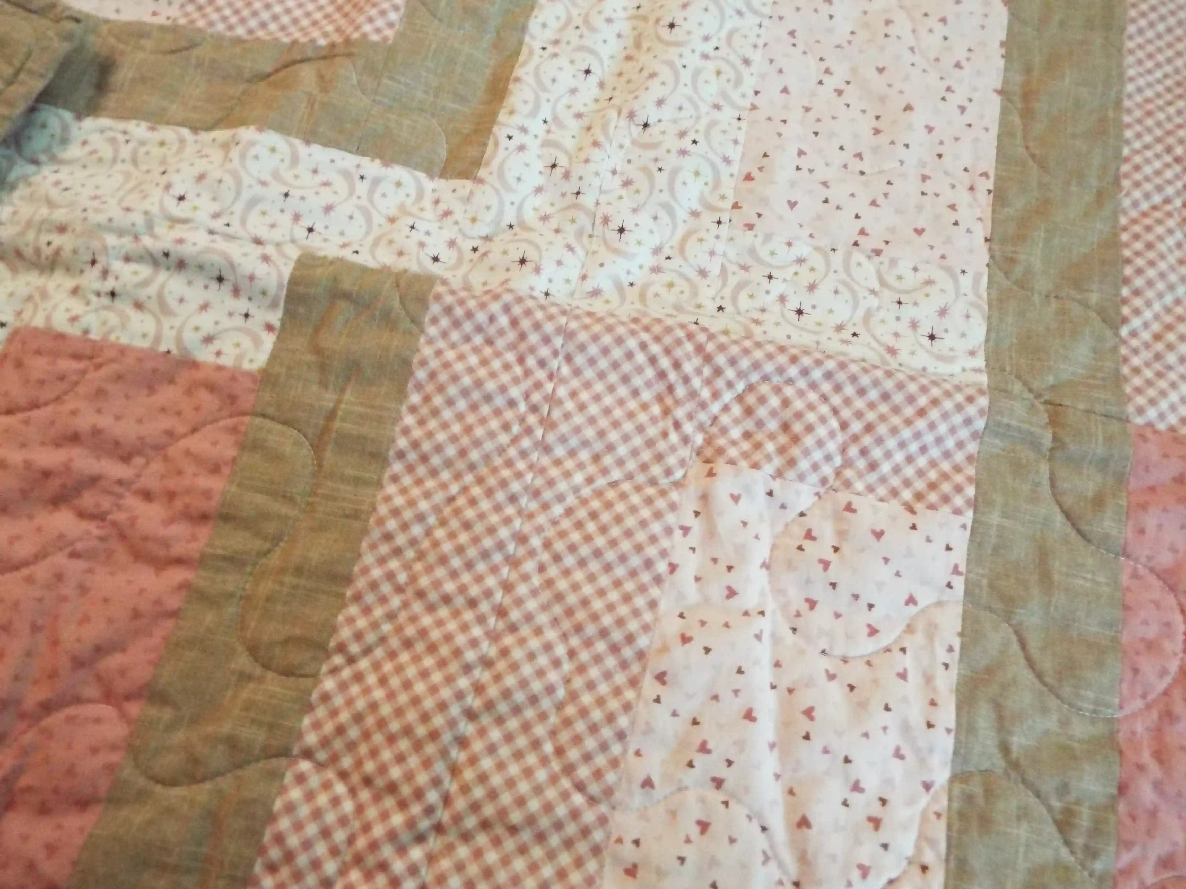 Detail of Blushing Pathways Baby Quilt showing quilt stitching.