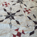 Detail showing some of the fabrics and the quilt stitching for Cartographer's Notes Queen Quilt.