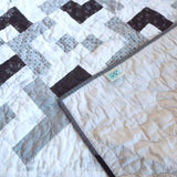 Quilt shown with the corner flipped over to show the backing and stitching detail.