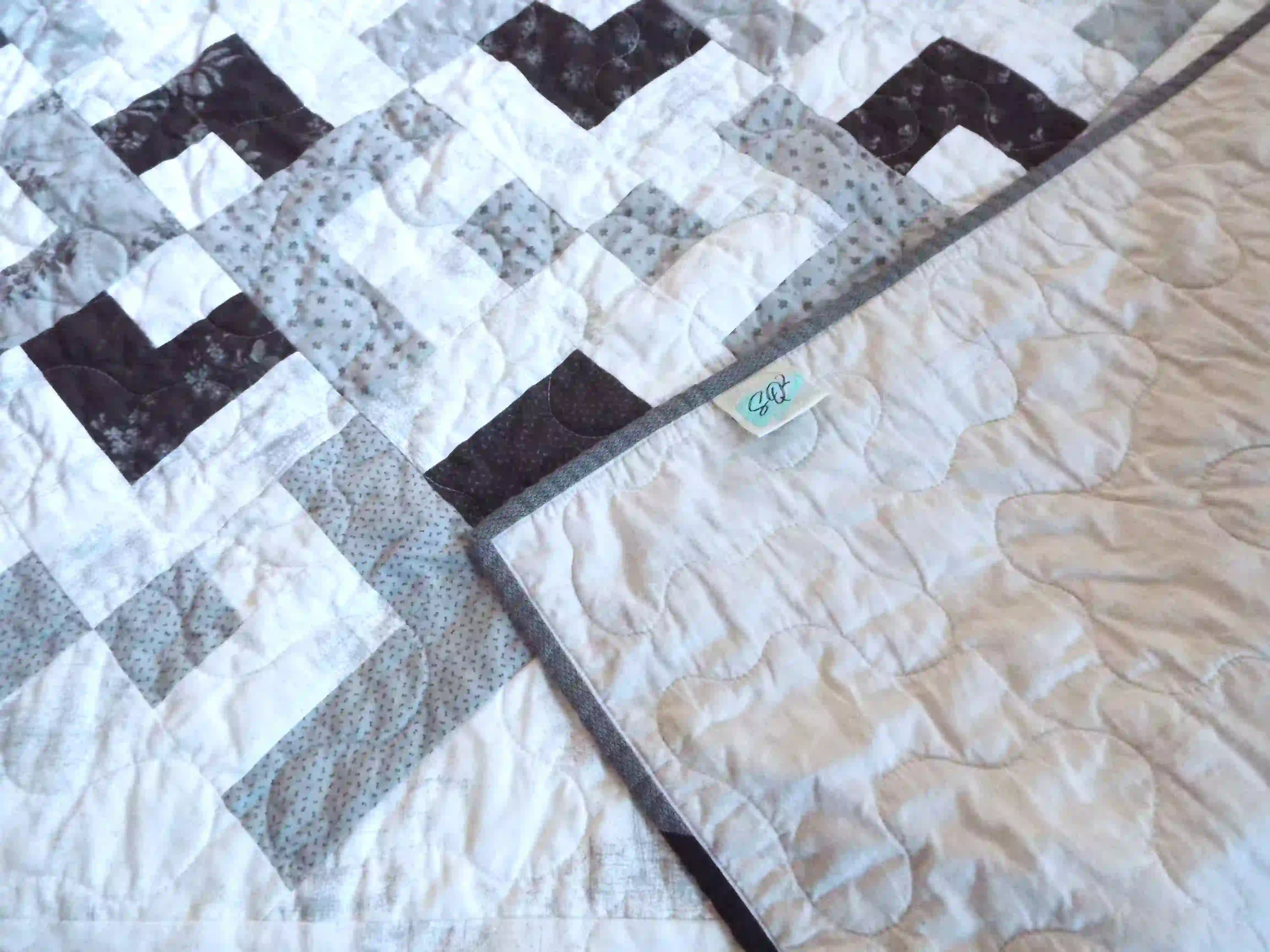 Quilt shown with the corner flipped over to show the backing and stitching detail.