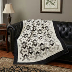 Quilt shown on a black leather couch