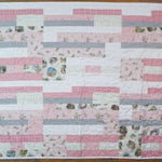 Flat lay of Daisy Dreams pink baby quilt