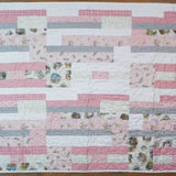 Flat lay of Daisy Dreams pink baby quilt