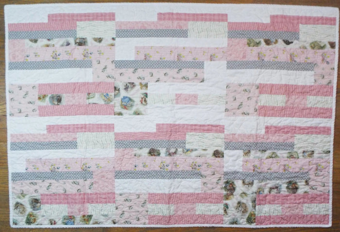 Flat lay of Daisy Dreams pink baby quilt