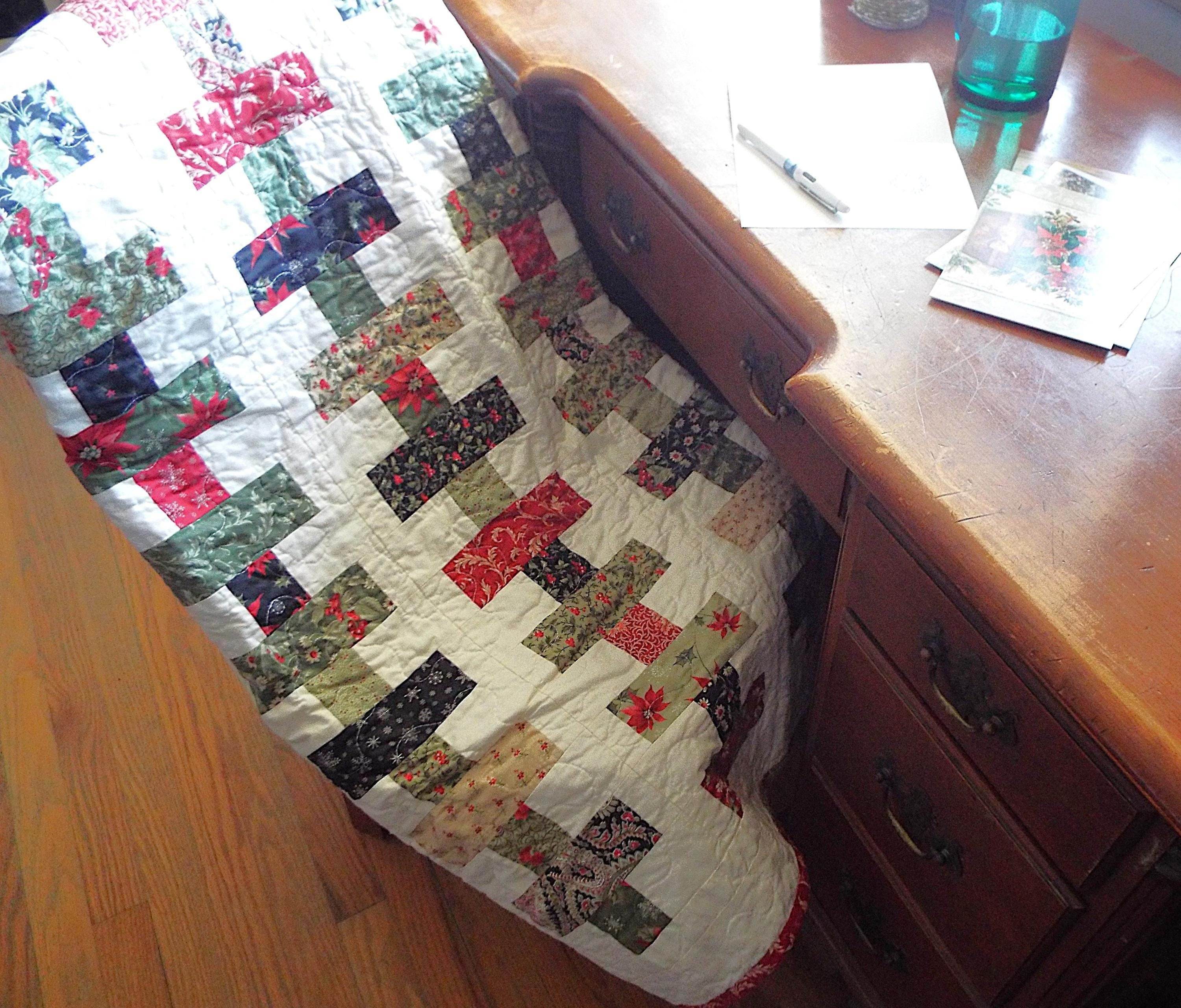 Handmade traditional holiday throw shown folded over a chair that is at a desk