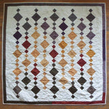 Embers at Dusk lap quilt shown in its entirety in a flat lay