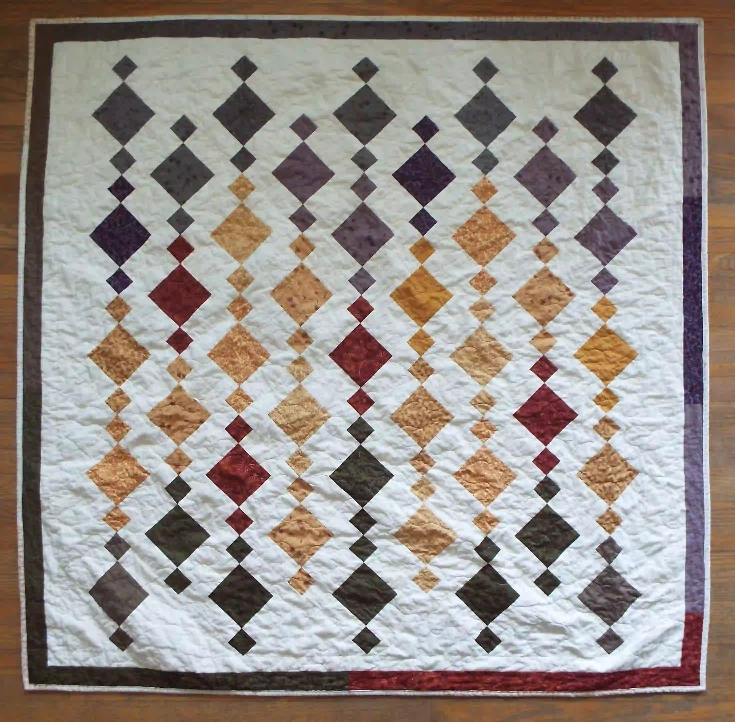 Embers at Dusk lap quilt shown in its entirety in a flat lay